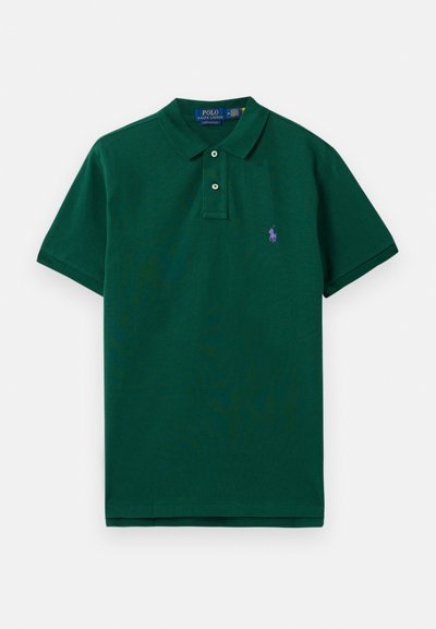 Zaļš kokvilnas polo krekls ar klasisku apkakli, īsām piedurknēm un mazu purpursarkanu logotipu kreisajā krūtī. Ar divu pogu slēgšanu.