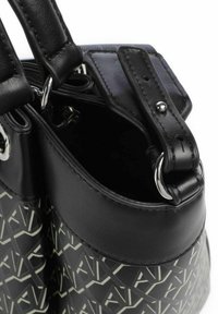 Borsa nera con un motivo geometrico, dotata di manici in pelle, accessori metallici e un bordo superiore liscio. All'interno è foderata con un tessuto scuro.