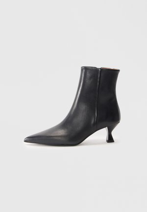Svart lær ankelstøvlett med spiss tå og elegant design. Har en lav, vinklet hæl og en glatt tekstur.