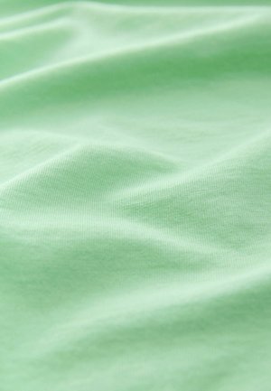 Tela verde claro con una textura suave, que presenta sutiles estrías y pliegues, mostrando una apariencia suave y transpirable.