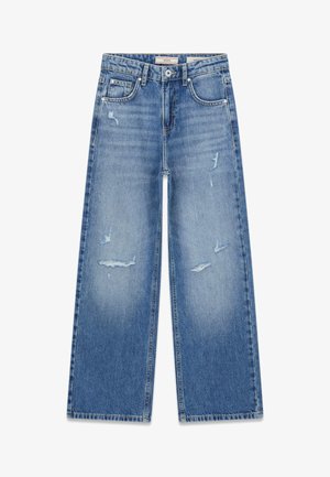Jean bleu taille haute à jambes larges avec des zones usées sur le devant des cuisses, passants pour ceinture et poches avant.