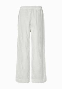 Białe spodnie typu wide-leg z elastycznym pasem, wykonane z materiału o fakturze z siatką małych kwadratowych wycięć.