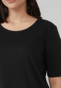 Black short-sleeve t-shirt in soft fabric with a wide round neckline and subtle stitching details at the edges. Smooth texture.