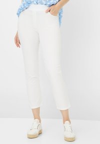 Witte capri-pantalons met een slim fit, voorzien van een gladde textuur en zijzakken. Gecombineerd met witte veterschoenen voor een casual uitstraling.