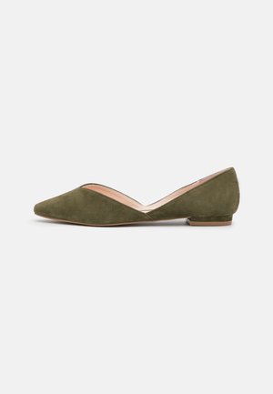 Olijfgroene suède platte schoen met spitse neus, lage hak en zijkant uitsnijding detail, getoond op een effen lichtgrijze achtergrond.