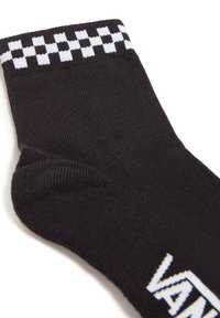Calzini neri in cotone con un motivo a scacchi bianchi nella parte superiore e un logo stampato in bianco di lato. Texture a costine in tutto il calzino.
