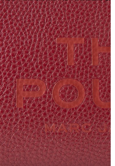 Raudona tekstūrinė odos danga su įspaustu daliniu tekstu "The Pot" ir "Marc J".