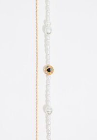 Collana a catena in tono oro che presenta sezioni alternate di perle bianche e un elemento decorativo centrale con accenti multicolori.