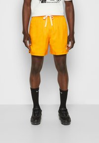Nike Sportswear M NSW SPE WVN LND FLOW SHORT - Calças de fato de treino - kumquat/white