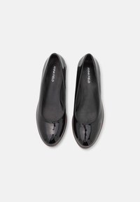 Ballerines en cuir verni noir présentant un bout rond, une texture lisse et un design minimaliste avec une semelle intérieure rembourrée.
