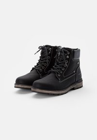 Botas de cuero negra hasta el tobillo con cordones, ojales de metal, un cuello acolchado y costuras en contraste. Presentan una suela texturizada para mayor tracción.