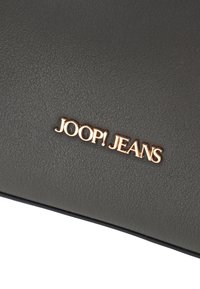 Portafoglio grigio in ecopelle con logo "JOOP! JEANS" in rilievo color oro metallico. Texture liscia con un lieve motivo a grana.