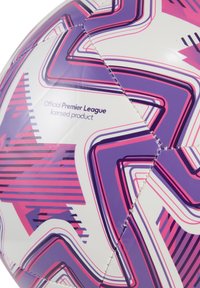 Oficiálna futbalová lopta Premier League s lesklým bielym povrchom, ktorý zdobia výrazné fialové a ružové zigzagové vzory a viditeľné detaily šitia.
