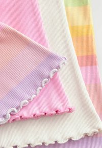 Collectie van ribbelstof monsters in pasteltinten, waaronder roze, lavendel, wit en oranje, met decoratieve geschulpte randen.