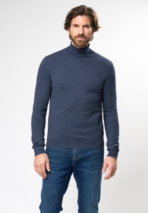 Suéter de cuello alto en azul oscuro, confeccionado con una suave tela de punto. Presenta mangas largas, puños y dobladillo acanalados, con un sutil detalle del logo en el pecho.