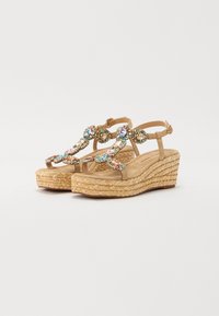 Sandali wedge in espadrilla beige con gemme decorative multicolori sulle cinghie, dotati di piattaforma in juta intrecciata e soletta imbottita.