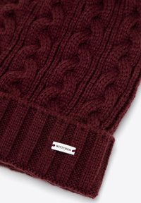 Berretto lavorato a maglia color bordeaux con motivo a treccia, risvolto a coste e una piccola etichetta argentata con la scritta "WITTCHEN" applicata. Materiale in morbida miscela di lana.