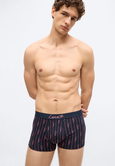 Tengerészkék boxeralsó piros "Love" feliratos mintával és függőleges csíkokkal. Puha anyag, elasztikus derékrész logóval, testhez simuló szabás.