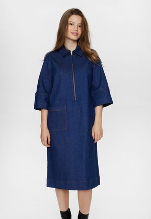 Denim jurk met een ritssluiting aan de voorkant, korte mouwen en een zak. Heeft contrasterende stiksels en een rechte pasvorm in een donkerblauwe kleur.