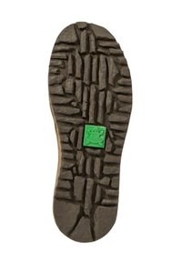 Suela de goma negra con profundas bandas de rodadura, con un patrón texturizado. Un pequeño logo de rana verde incrustado en el centro.