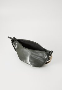 Piccolo borsa a tracolla grigio scuro con cerniera nera parzialmente aperta e tracolla beige regolabile su sfondo bianco.