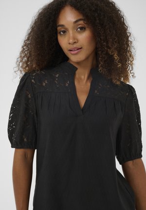 Črna bluza z rokavi na napihnjene kratke rokave z detajli iz čipke, izrezom v obliki ključavnice in nežnimi gubami na sprednji strani za dodaten teksturni učinek.