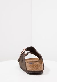 Sandale en daim marron avec une semelle en liège, dotée de sangles réglables et d'un semelle texturée. Design minimaliste avec un profil plat.