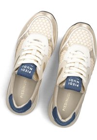 Beige sneakers met gaaspanelen, metallic accenten en witte veters. Blauwe textiele tong met merknaam. Dikke rubberen zool.