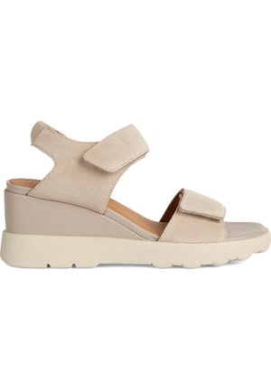 Sandalias de cuña de ante beige con dos correas ajustables de velcro, zona de los dedos suave y suela de goma ligera con un acabado texturizado.