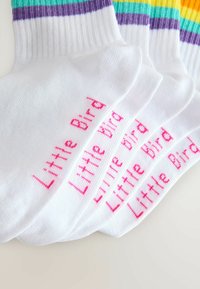 Fire hvide ankelstrømper med farverige stribede manchetter i teal, lilla og gul, hver mærket "Little Bird" med pink tekst.