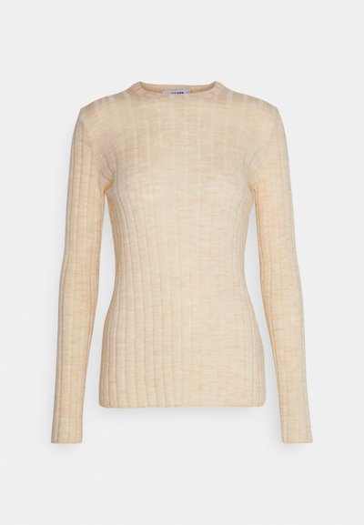Haut à manches longues côtelé en beige clair, avec un col rond et une silhouette ajustée, fabriqué à partir d'un tissu doux et extensible.