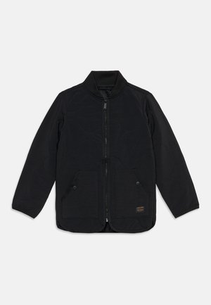 Veste noire zippée avec manches longues, col montant, deux poches avant à boutons-pression et un petit écusson logo en bas sur le devant.