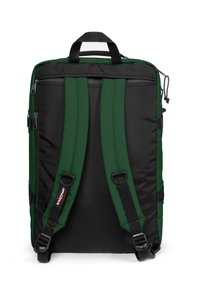 Musta ja vihreä reppu, jossa on pehmustetut säädettävät hihnat, ylhäällä oleva kantokahva ja vetoketjulliset taskut. Kestävä kangas, jonka pinta on sileä.