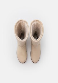 Botas de cuero beige con un exterior suave y forro de piel sintética suave. Altura hasta la mitad de la pantorrilla y diseño de punta redonda. Suelas planas.