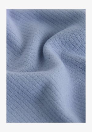 Šviesiai mėlynas audinys su tekstūrizuota, raukšlėta raštais. Minkšta, lygi tekstūra su subtiliu blizgesiu. Iškilios raukšlės kuria švelnias šešėlius.