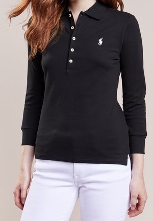 Polo noir à manches longues en coton, avec un col à trois boutons, un logo blanc sur la poitrine gauche et une coupe légèrement ajustée.