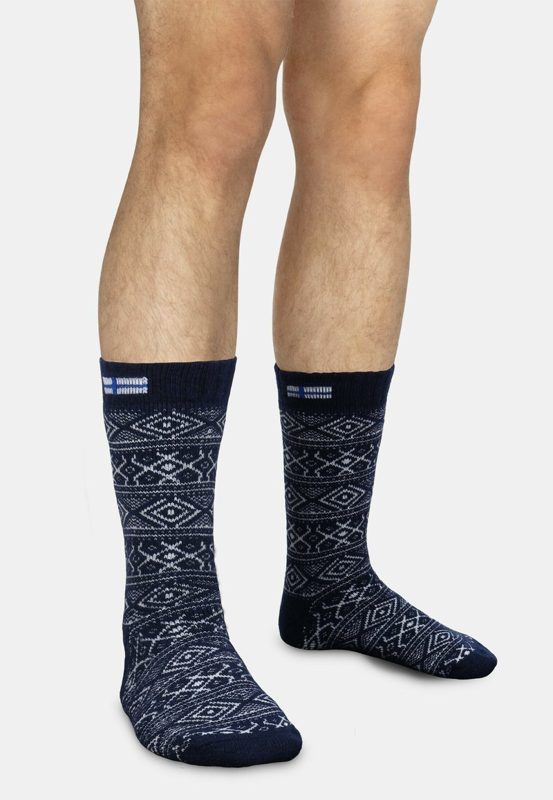 Marineblaue Socken mit einem geometrischen weißen Muster, ausgestattet mit einem gerippten Bündchen und verstärkter Spitze, gefertigt aus einem langlebigen, weichen Material.