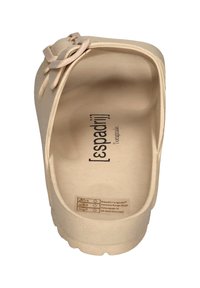 Beige slip-on sandal with textured surface, round toe, and decorative strap detail. Logo printed on the insole. Lightweight material.