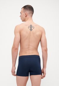 Navy blå boxershorts laget av myk stoff med en merket linning, og har et elegant design uten synlige mønstre.