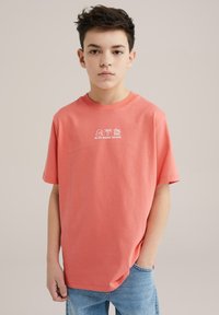 Koronkowa koszulka z krótkim rękawem, okrągłym dekoltem i grafiką "BLUE RIDGE DENIM" z białymi ikonami. Casualowy fason, wykonana z miękkiej bawełny.