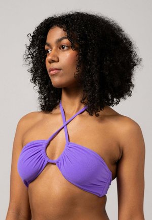 Lila bikiniöverdel med ett korsremdesign, som har samlad tyg och en cirkulär detalj i mitten. Slätt, strukturerat material.