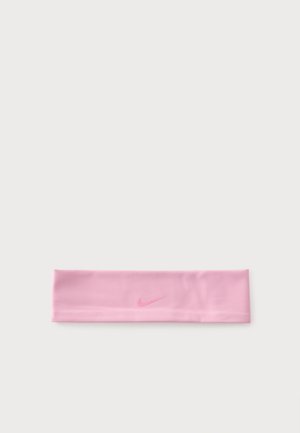 Bandeau de sport en tissu rose clair avec un logo Nike Swoosh rose foncé discret centré sur un fond blanc uni.