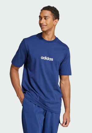 T-shirt en coton bleu marine avec un col rond et des manches courtes, arborant un logo "adidas" blanc au centre.