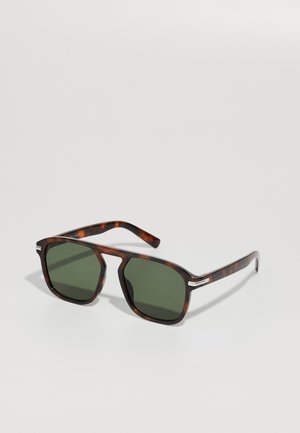 Óculos de sol em padrão tartaruga com armação quadrada, lentes verdes, destaque em prata nas hastes, textura suave e design leve.