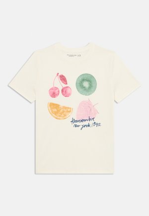 Krem majica s voćnim grafike: ružičaste trešnje, zelena kivija, narančina kriška, ružičasta jagoda i tekst "Abercrombie New York 1992."