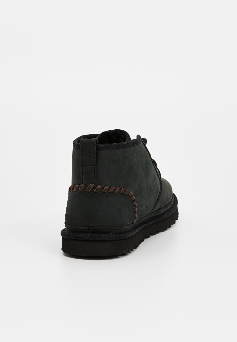 Dunkelgrüne Wildleder-Stiefeletten mit braunen Nähten, einer runden Zehenpartie und einer gepolsterten schwarzen Sohle. Eignen sich für die Freizeit.