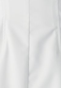 Biely textil s jemnou diagonálnou textúrou. Má čistý, hladký povrch a precízne švy. Neobsahuje viditeľné kovanie ani vzory.