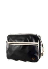 Borsa nera in pelle sintetica con strisce orizzontali bianche, zip nella parte superiore, forma rettangolare e accento del logo dorato in basso a destra.