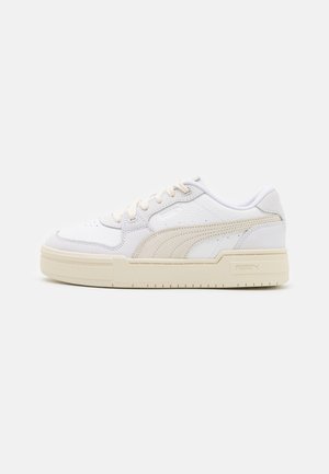 Sneaker bianco con tomaia in pelle texturizzata, accenti beige, punta rotonda e suola in gomma. Presenta dettagli del logo e chiusura con lacci.