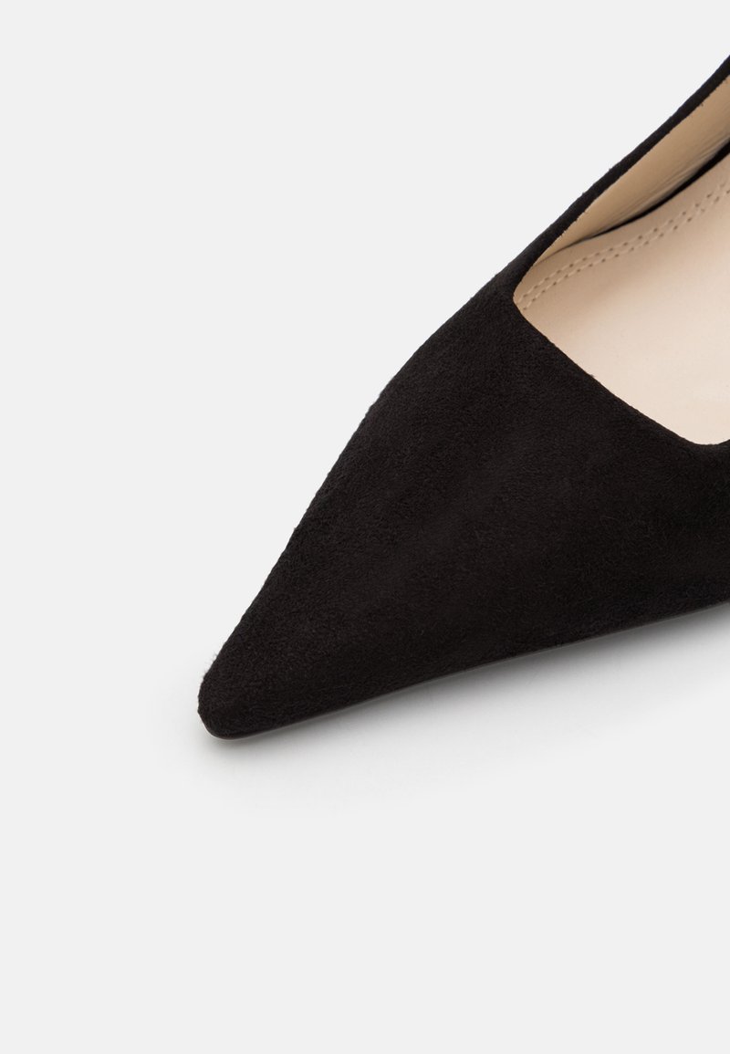 Scarpa nera in suede con punta affusolata e design a bassa scarpa, dotata di una fodera interna liscia e di una silhouette elegante, che enfatizza uno stile minimalista.